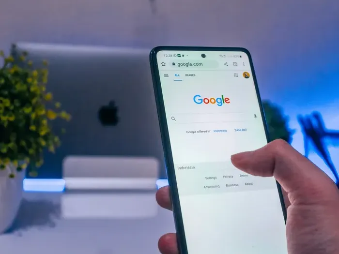 Person holding smartphone with Google search page open, representing online visibility for Town Link Hub